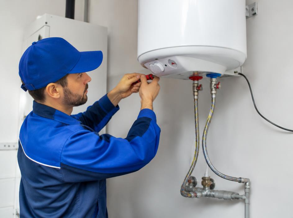 Technician servicing a wall-mounted electric water heater